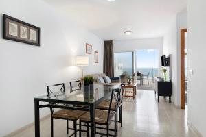 a dining room and living room with a table and chairs at Callao Beach 8 in Arrieta