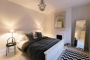 1 dormitorio con 1 cama grande y espejo en Beautiful house, Cirencester centre, parking, en Cirencester