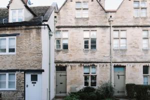 una vieja casa de ladrillo con dos garajes en Beautiful house, Cirencester centre, parking, en Cirencester