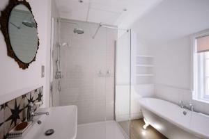 a white bathroom with a shower and a sink at Beautiful house, Cirencester centre, parking in Cirencester