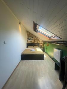 ein Schlafzimmer mit einem Bett und einem Dachfenster in der Unterkunft Room's near Belval university in Esch-sur-Alzette