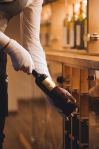 a person is holding a bottle of wine at Hotel IN in Banja Luka