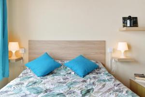 a bedroom with a bed with two blue pillows at Viviendas El Pescador - Timón in El Golfo