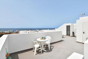 - un balcon blanc avec une table et des chaises blanches dans l'établissement Viviendas El Pescador - Timón, à El Golfo