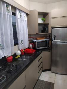 a kitchen with a counter top with a microwave and a refrigerator at Vista da Lagoa in Imbituba