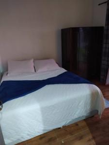 een slaapkamer met een bed met een blauwe en witte deken bij Vista da Lagoa in Imbituba