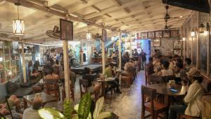 Anjoned Hostel & Cafe في أنجونا: زحمة الناس جالسين على الطاولات في المطعم
