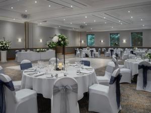 a banquet room with white tables and white chairs at Delta Hotels by Marriott Swindon in Swindon