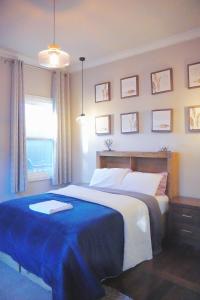 1 dormitorio con 1 cama grande con manta azul en Cozy BoxHill - Modern Stylish Share House, en Box Hill