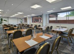 a classroom with wooden tables and chairs and a large window at Delta Hotels by Marriott Swindon in Swindon