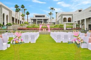 a set up for a wedding with white chairs and flowers at Pramod Lands End Resort, a member of Radisson Individuals in Gopālpur