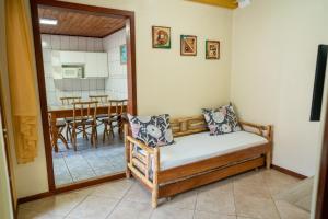 a room with a bed and a kitchen with a table at Moradas in Guarda do Embaú