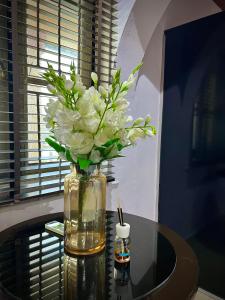 eine Vase mit weißen Blumen auf einem Tisch in der Unterkunft The Orange Door Annex 2 in Lekki