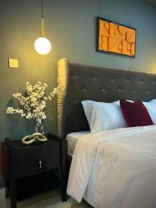 sypialnia z łóżkiem i stołem z wazonem kwiatów w obiekcie The Orange Door Annex 2 w mieście Lekki