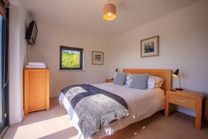 a bedroom with a bed and a television in it at Stac Polly Lodge in Achiltibuie