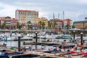 a group of boats docked in a harbor with buildings at Apartamento Vila de Neda in Neda