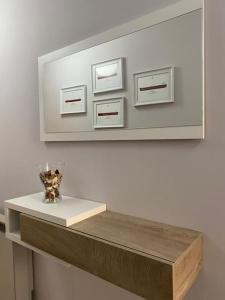 a mirror above a shelf with a vase on it at Apartamento Vila de Neda in Neda