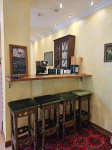 a bar with four stools in front of a counter at Barrister's apartments with fireplace in Šiauliai