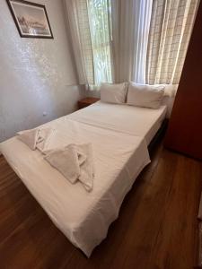a bed with white sheets and a shirt and a window at Hotel Antique in Istanbul
