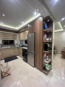 a kitchen with a stainless steel refrigerator in a room at fibre optique, propre, calme, équipé, caméras de surveillance, climatisations réversibles pour chauffer, télévisions, parking, parc, agadir, 7 personnes, accès à pieds aux magasins, cafés et restaurants in Agadir