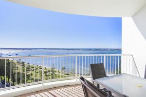 a balcony with a table and chairs and a view of the ocean at Crystal Bay On The Broadwater in Gold Coast
