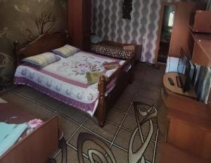 um pequeno quarto com uma cama e uma cómoda em Petrovskaya Pristan 2 em Cholpon-Ata