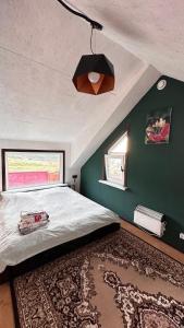 Un dormitorio con una cama grande y una pared verde en Дом в горах Уютный дом с потрясающим видом и огромной террасой en Besqaynar