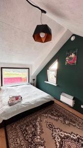 sypialnia z dużym łóżkiem i zieloną ścianą w obiekcie Дом в горах Уютный дом с потрясающим видом и огромной террасой w mieście Besqaynar