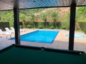 a swimming pool with a view of a swimming pool at Chácara espaçosa e aconchegante em Juquitiba Sp in Juquitiba