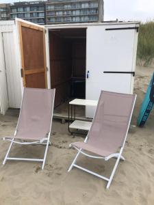 two folding chairs and a table in the sand at CONDO Romain in Nieuwpoort +2 photos