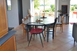 ein Esszimmer mit einem weißen Tisch und Stühlen in der Unterkunft Gite sublime campagne in La Baconnière