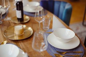 a wooden table with plates and wine glasses on it at Exklusive Ferienwohnung Arthur in Zeitz