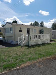 a mobile home with a porch and a white fence at Happy place no4 in Ringwood