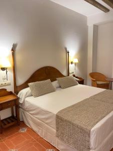 a bedroom with a large white bed with two pillows at Hotel Rural Cazorla Posada del Cordobés in Cazorla