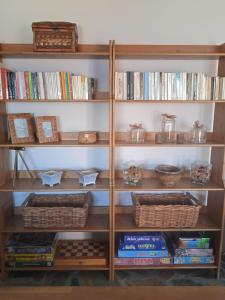 a book shelf filled with books and baskets at Calma in Perdika