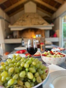 einen Tisch mit Tafeln aus Trauben und einem Glas Wein in der Unterkunft Sea Relaxing Apartment in Bibinje