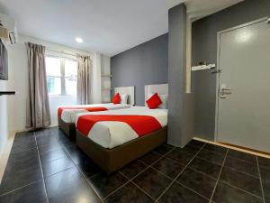 Cette chambre d'hôtel comprend 2 lits avec des oreillers rouges. dans l'établissement Good2Stay Budget Hotel, à Malacca