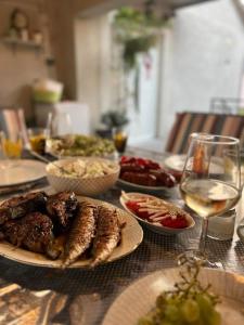 einen Tisch mit Speisen und einem Glas Wein in der Unterkunft Sea Relaxing Apartment in Bibinje