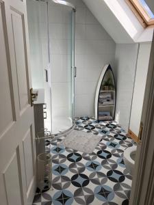 a bathroom with a shower and a black and white tile floor at Rossnowlagh Beach House in Donegal