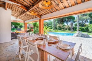 - une salle à manger avec une table, des chaises et une piscine dans l'établissement Dream Villa 300m2 & stunning 4000m2 private garden, à Cannes