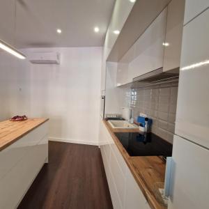 a kitchen with white walls and a sink and a counter at NewPearl Apartman in Sopron