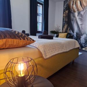 a bedroom with a bed with a lamp on it at NewPearl Apartman in Sopron +28 photos