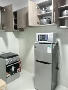 a kitchen with a microwave on top of a refrigerator at Amalya suites by TJ in Eldoret