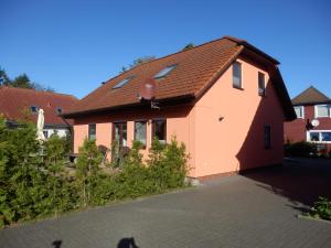 una casa rosa con techo marrón en Haus Zeitlos, en Zingst