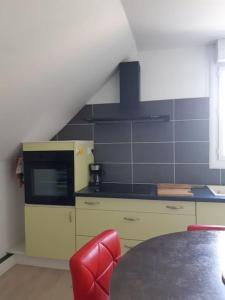 eine Küche mit Tisch und Herd oberen Backofen in der Unterkunft Logement à 6 km de Redon, à 35 km de la mer in Rieux