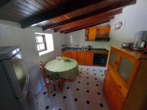 a small kitchen with a table and a refrigerator at La Carpintera in Tijarafe