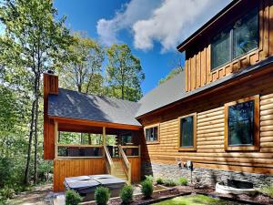a log cabin with a porch and a house at Black Diamond Lodge in McHenry