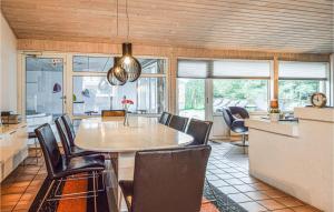 a kitchen and dining room with a table and chairs at Beautiful Home In Blvand With 5 Bedrooms, Private Swimming Pool And Indoor Swimming Pool in Blåvand