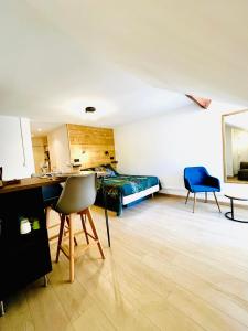 Habitación con cama, escritorio y sillas. en Le Bellevue en Barcelonnette
