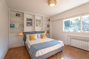 - une chambre avec un lit doté d'oreillers jaunes et d'une fenêtre dans l'établissement Dream Villa 300m2 & stunning 4000m2 private garden, à Cannes